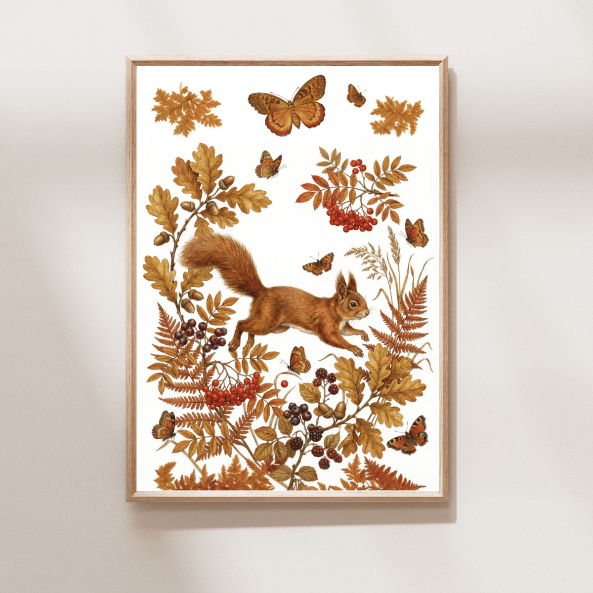 Framed wall art featuring an autumn nature illustration with a squirrel, butterflies, leaves, and berries on a white background, hung on a light neutral wall.