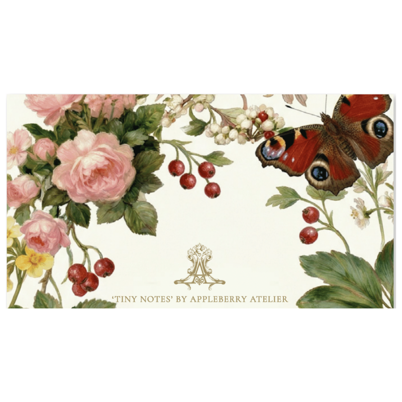 A rectangular stationery card or note pad cover featuring a botanical illustration with pink and white flowers, green leaves, red berries, and a peacock butterfly on an off-white background. Gold text at the bottom reads “TINY NOTES’ BY APPLEBERRY ATELIER.