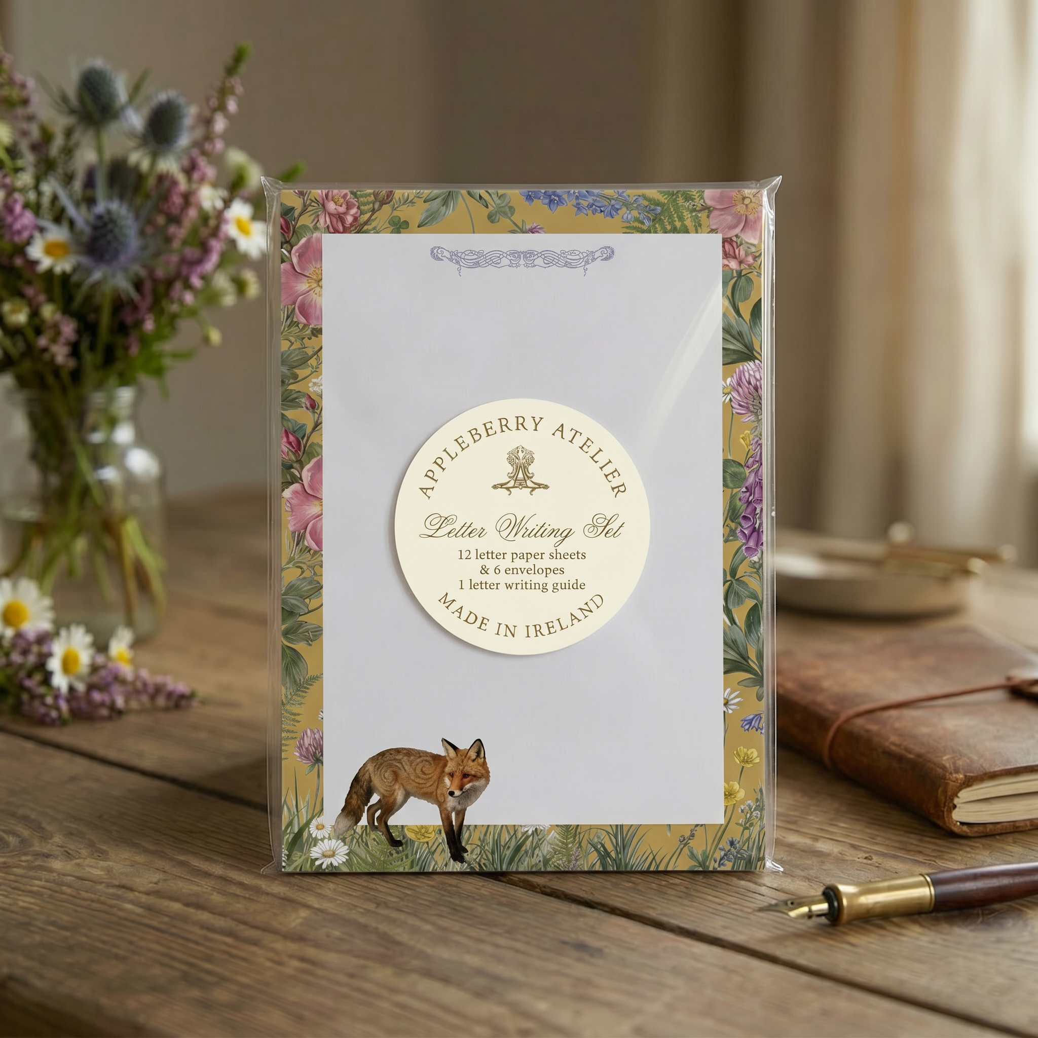 Letter writing set with floral design and fox illustration on a wooden surface.