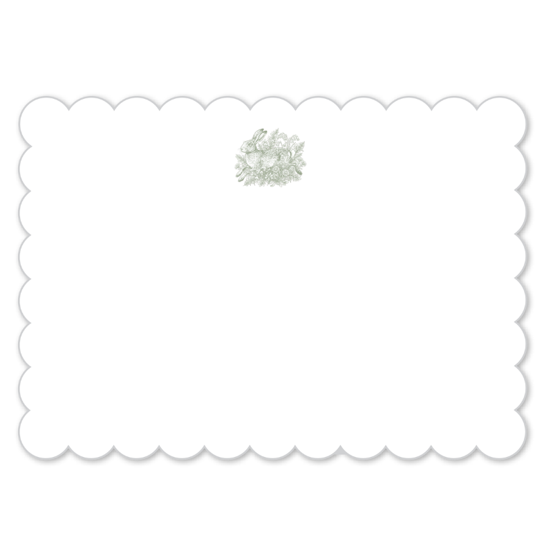 A white rectangular card or label with a scalloped border and a small pale green floral embellishment near the top center, shown on a white background.