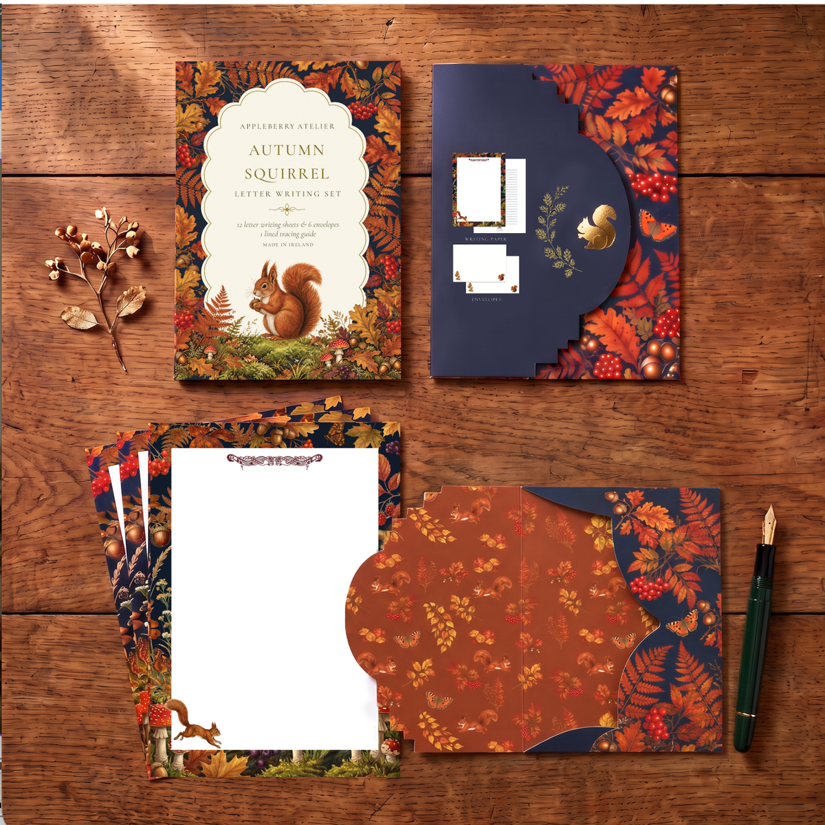 Autumn-themed stationery letter writing set arranged on a wooden tabletop, including a book-style cover with a squirrel illustration, a navy envelope with autumn leaf border, several patterned paper sheets, and a green pen.