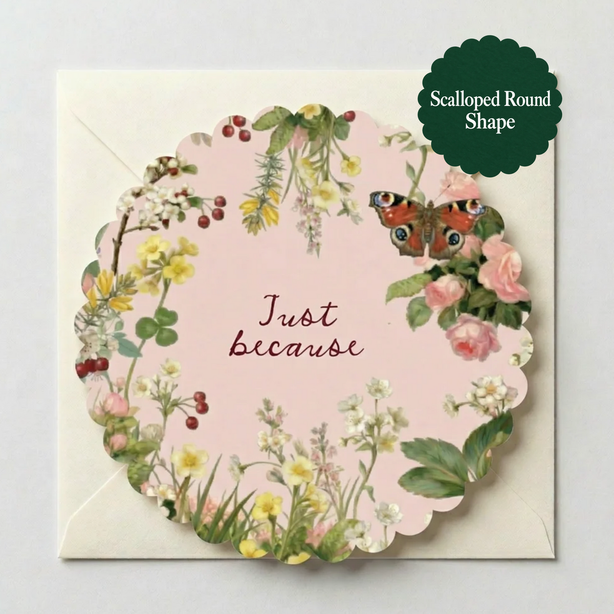 A scalloped round greeting card reading 'Just Because' with a floral border and a butterfly illustration, placed on top of a cream envelope. A dark green badge in the top right reads 'Scalloped Round Shape.