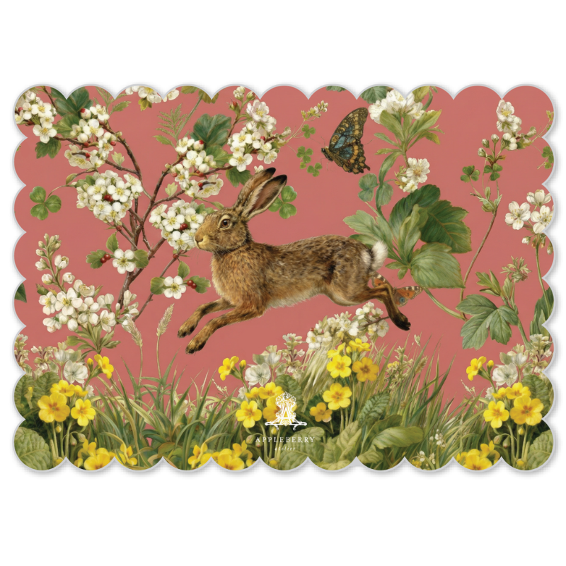 A scalloped-edge decorative print or card featuring a brown hare jumping among white blossoms, green leaves, yellow wildflowers, and a butterfly on a dusty pink background.