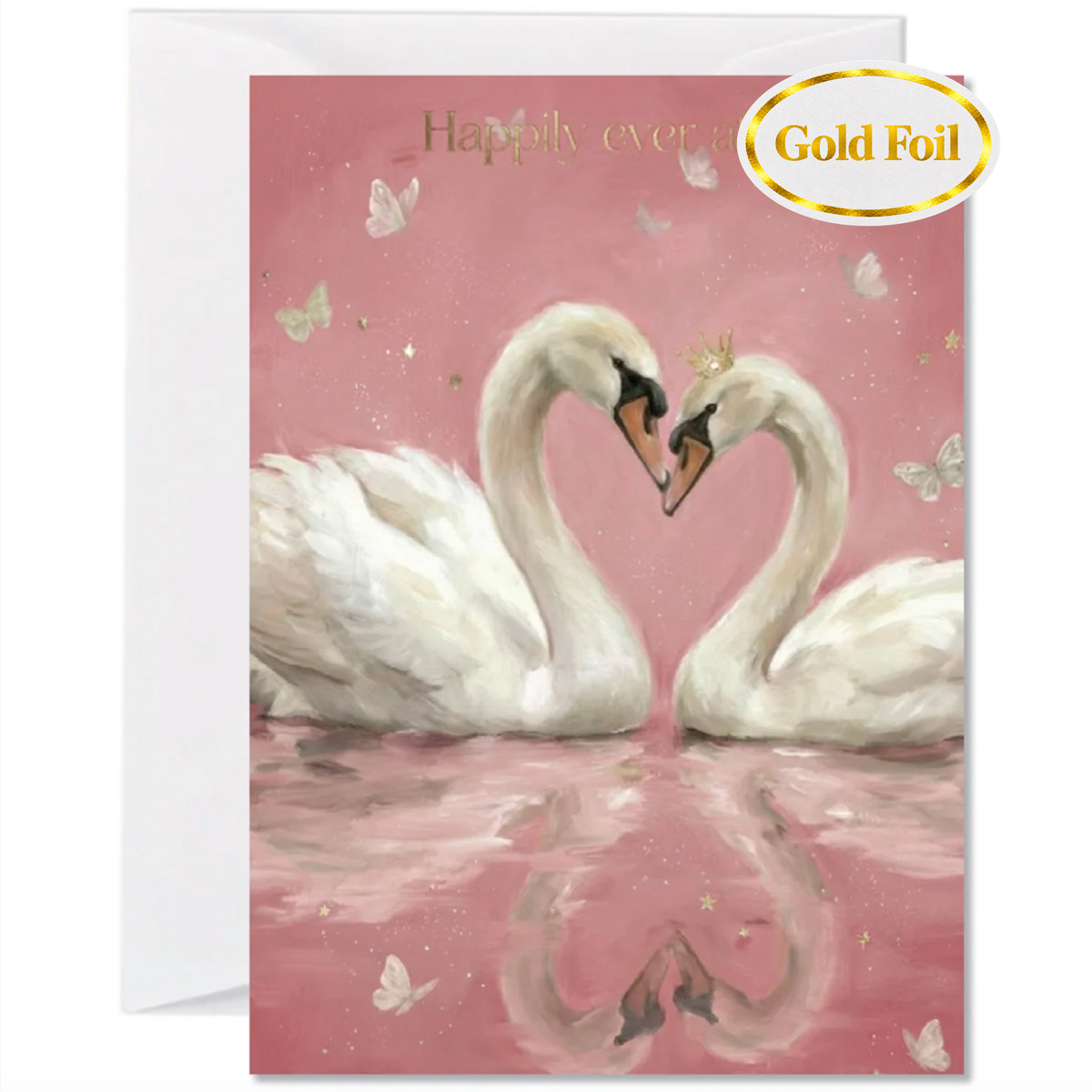 A pink greeting card featuring two white swans facing each other with their necks forming a heart shape, on a pink reflective water surface. The card has gold foil text reading 'Happily ever.